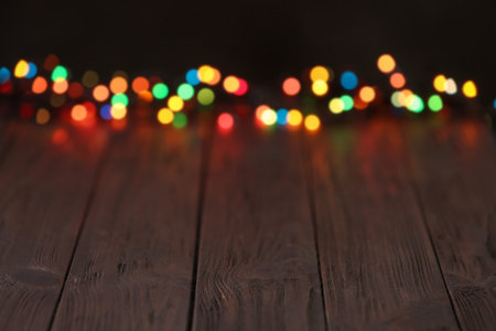 Colorful lights on wooden table, blurred view. Space for textの写真素材