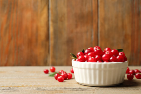 Tasty ripe cranberries on wooden table, closeup. Space for textの写真素材