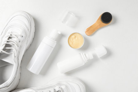 Flat lay composition with stylish footwear and shoe care accessories on white backgroundの写真素材