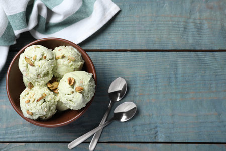 Delicious pistachio ice cream served on blue wooden table, flat layの写真素材
