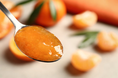 Spoon with delicious tangerine jam, closeup. Space for textの写真素材