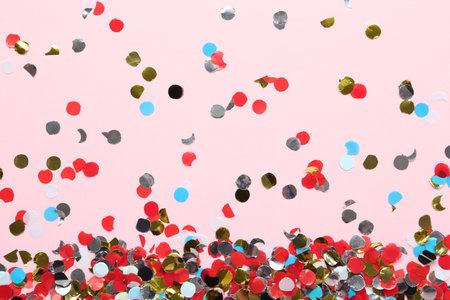 Shiny colorful confetti on light pink background, flat layの写真素材