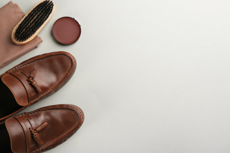 Flat lay composition with shoe care accessories and footwear on light grey background. Space for textの写真素材