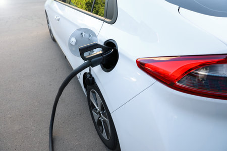 Charging modern electric car from station outdoorsの写真素材