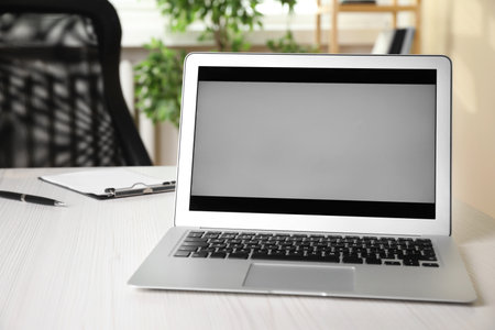Modern laptop on white wooden table in officeの写真素材