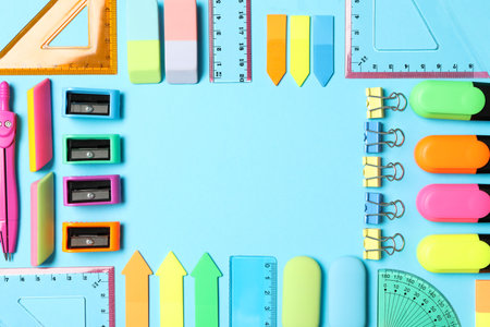 Frame of different stationery on light blue background, flat lay with space for text. back to schoolの写真素材