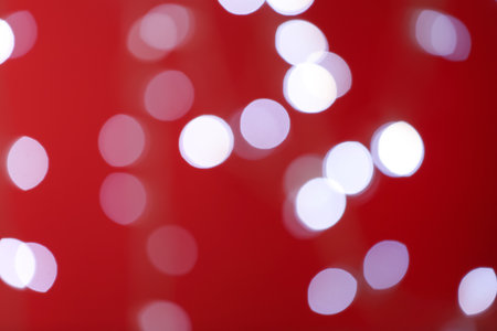 Blurred view of festive lights on red background. bokeh effectの写真素材