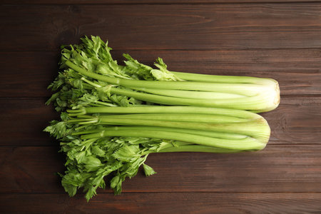 Fresh ripe green celery on wooden table, flat layの写真素材