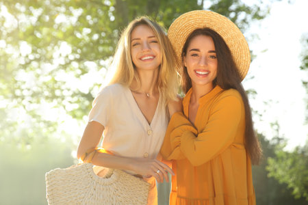 Beautiful young women in stylish dresses outdoorsの写真素材