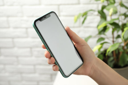 MYKOLAIV, UKRAINE - JULY 8, 2020: Woman holding Iphone 11 Pro Max with blank screen indoors, closeupのeditorial素材