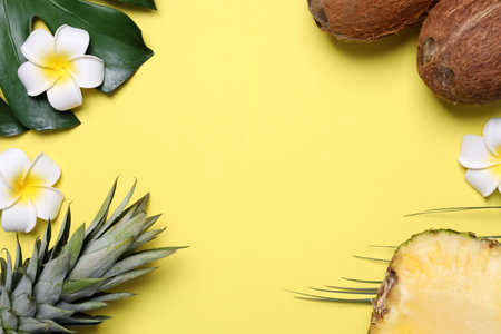Flat lay composition with pineapples and coconuts on yellow background, space for textの写真素材