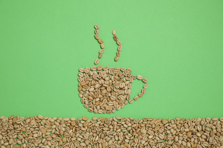 Cup of hot drink, composition made with coffee beans on green background, flat layの写真素材