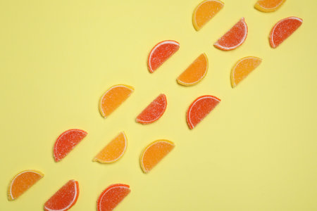 Many sweet jelly candies on pale yellow background, flat layの写真素材