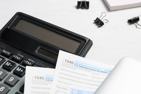 Calculator, documents and clips on white wooden table, closeup. tax accountingの写真素材