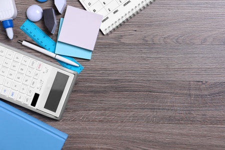 Different school stationery on wooden table, flat lay. Space for text