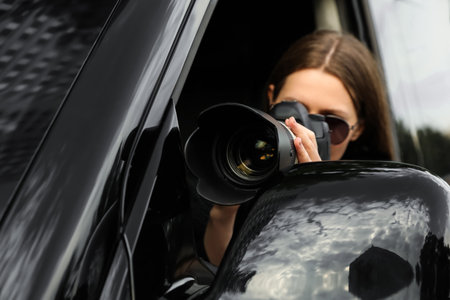 Private detective with camera spying from car, focus on lensの写真素材