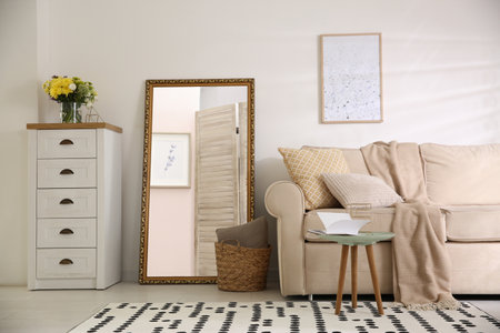 Large mirror and comfortable sofa in living room. interior designの写真素材