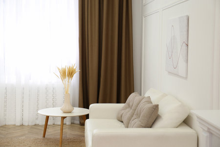 Sofa and window with brown curtains in simple room interiorの写真素材