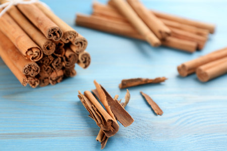 Aromatic cinnamon sticks on light blue wooden table, closeupの写真素材
