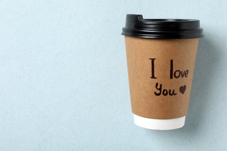 Paper cup with phrase I Love You on light blue background, top viewの写真素材