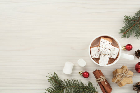 Flat lay composition with delicious marshmallow cocoa and Christmas decor on white wooden table. Space for textの写真素材