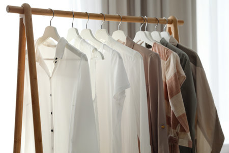Different stylish clothes on rack in the roomの写真素材