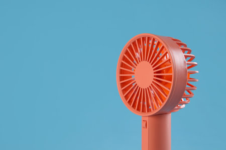 Modern electric fan on light blue background. Space for textの写真素材