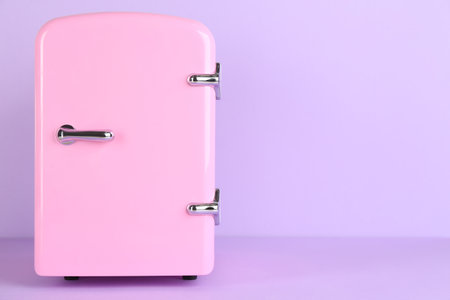 Cosmetic refrigerator on violet background, space for textの写真素材