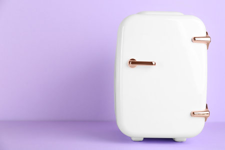 Cosmetic refrigerator on violet background, space for textの写真素材