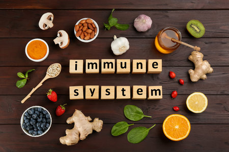 Cubes with phrase Immune System and fresh products on wooden table, flat layの写真素材
