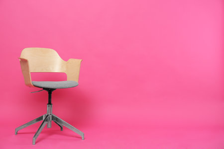 Comfortable office chair on pink background, space for textの写真素材