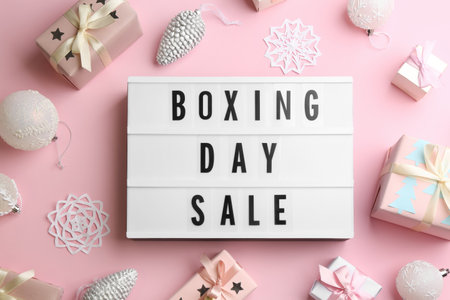 Lightbox with phrase BOXING DAY SALE and Christmas decorations on light pink background, flat layの写真素材