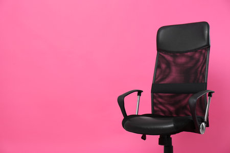Comfortable office chair on pink background, space for textの写真素材