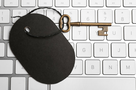 Vintage key with blank tag on keyboard, top view. Keyword conceptの写真素材