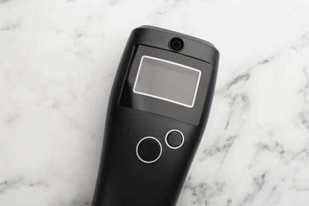 Modern breathalyser with blank screen on white marble table, top viewの写真素材