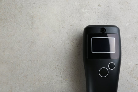 Modern breathalyser with blank screen on light gray stone table, top view. Space for textの写真素材