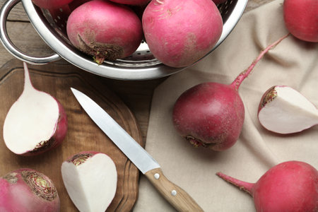 Red turnips and knife on wooden table, flat layの写真素材