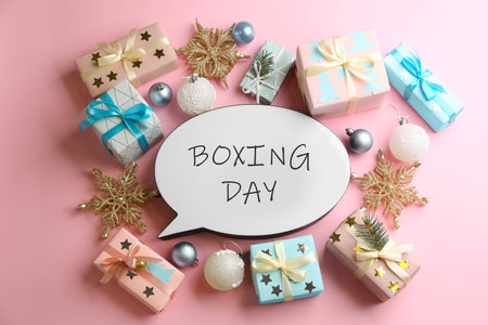 Speech bubble with phrase BOXING DAY and Christmas decorations on light pink background, flat layの写真素材