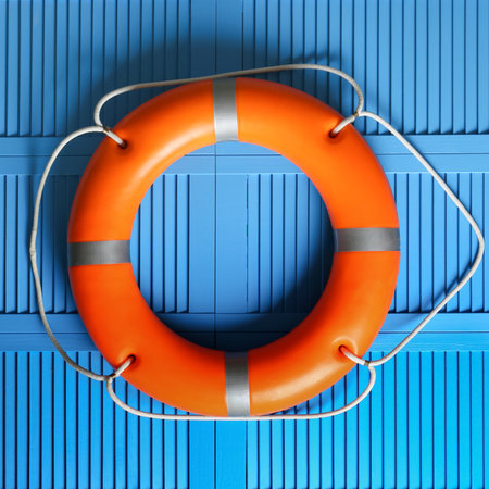 Orange lifebuoy on blue wooden background. Rescue equipmentの写真素材