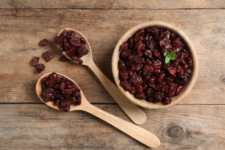 Flat lay composition with tasty dried cranberries on wooden tableの写真素材