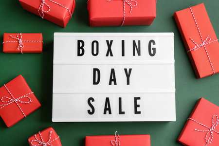 Lightbox with phrase BOXING DAY SALE and Christmas decorations on green background, flat layの写真素材