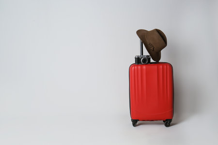 Travel suitcase with hat and camera on light gray background, space for text. summer holidaysの写真素材