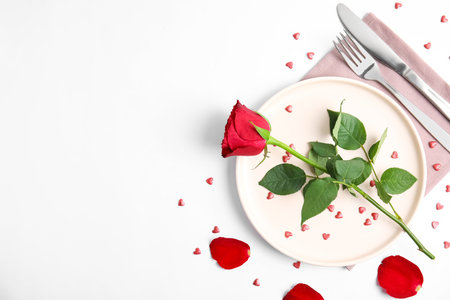 Beautiful table setting for romantic dinner on white background, flat lay. Valentine's day celebrationの写真素材