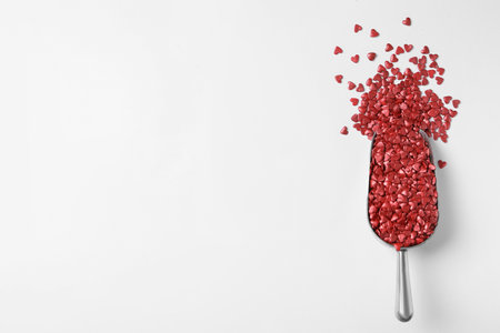 Bright heart shaped sprinkles in scoop on white background, top viewの写真素材