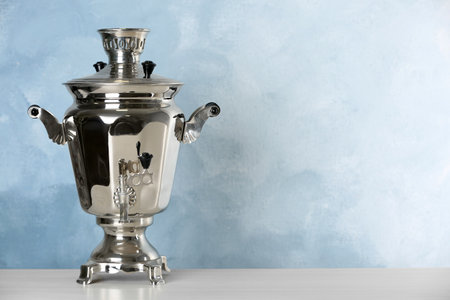 Metal samovar on gray table against light blue background, space for text. Russian tea cultureの写真素材