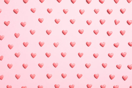 Tasty bright heart shaped sprinkles on pink background, flat layの写真素材