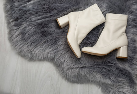 Pair of stylish leather shoes on faux fur, flat layの写真素材