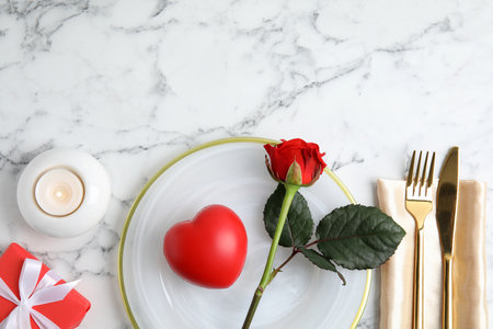 Place setting with decorative heart on white marble table, flat lay and space for text. Valentine's day romantic dinnerの写真素材
