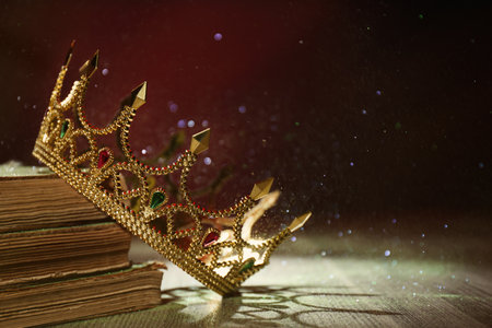 Beautiful golden crown and old books on wooden table. fantasy itemの写真素材