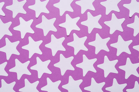 White star shaped confetti on violet background, flat layの写真素材